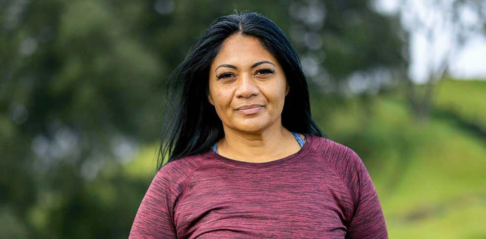 A headshot of a middle-aged Pasifika woman, smiling softly at the camera.
