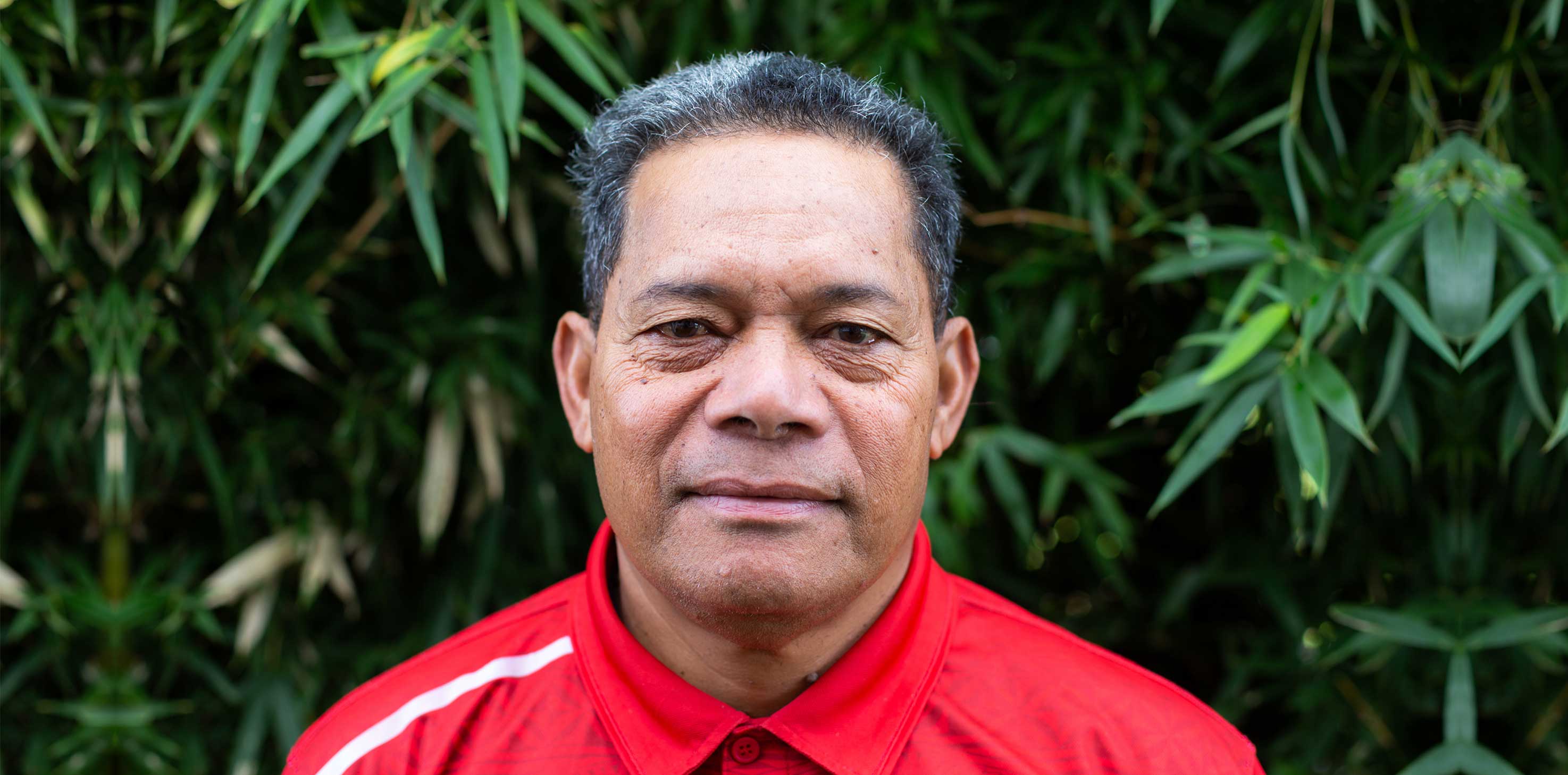 A headshot of a middle-aged Pasifika man, looking into the camera with a neutral expression.